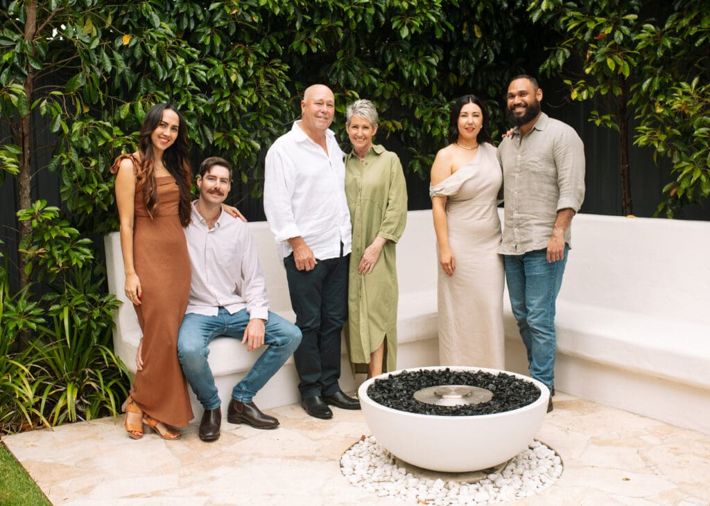 Adult family all looking at the camera in very elegant image , some are sitting and some are standing and all very relaxed looking at the camera