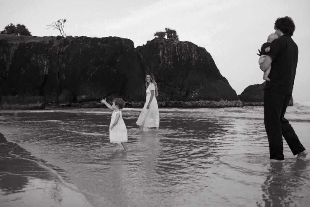 A family chases after their toddler at Dreamtime Beach 
